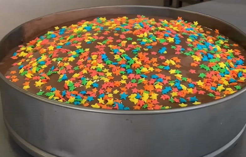 Bolo de chocolate simples e fofinho recheado e com confetes coloridos
