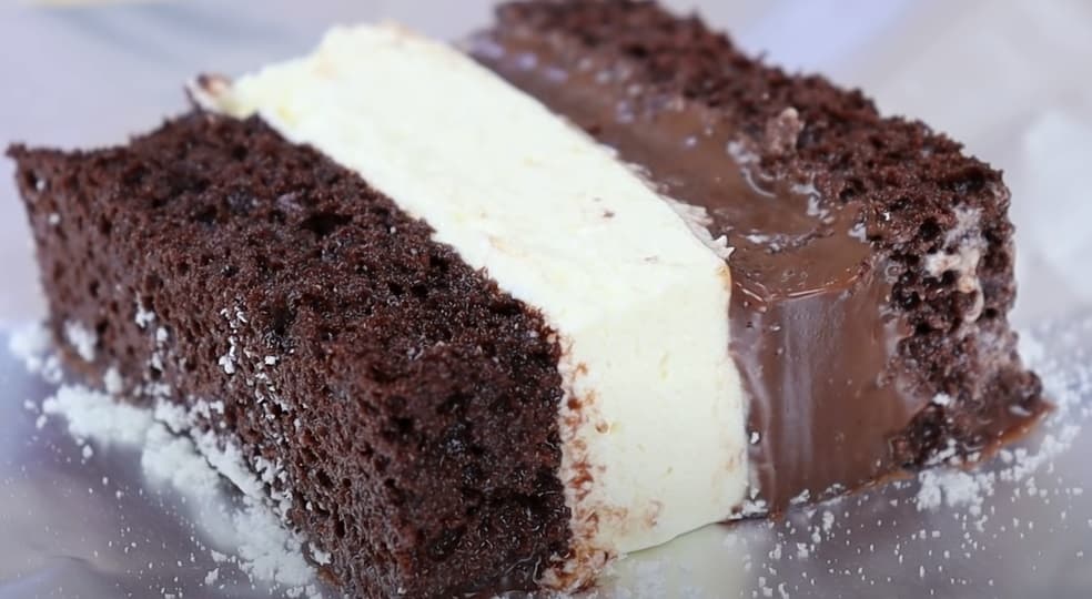 Bolo de chocolate fofinho recheado com brigadeiro branco e preto e embrulhado em papel alumínio